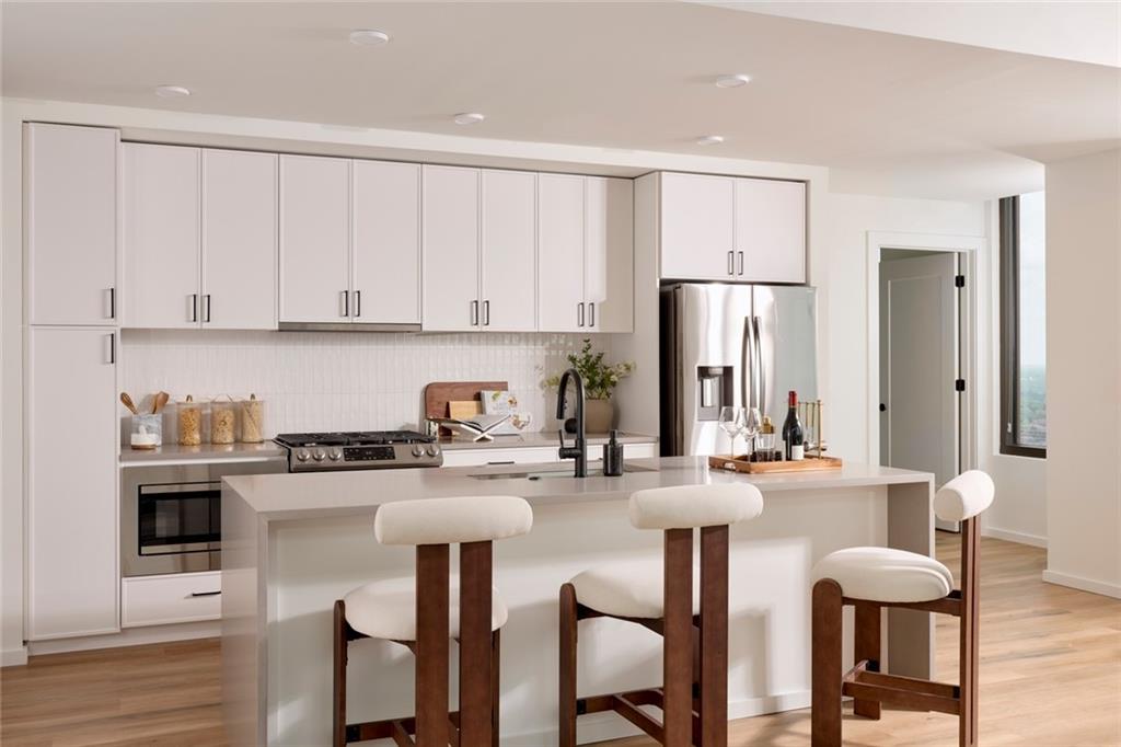 1081 Juniper Street Northeast, Unit S2C Atlanta, GA 30309 - Photo 5 of 46 a kitchen with stainless steel appliances granite countertop a white cabinets and a refrigerator