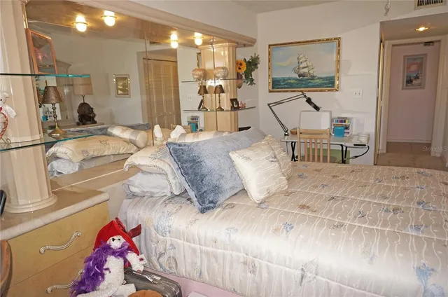 a bedroom with a bed and a large mirror