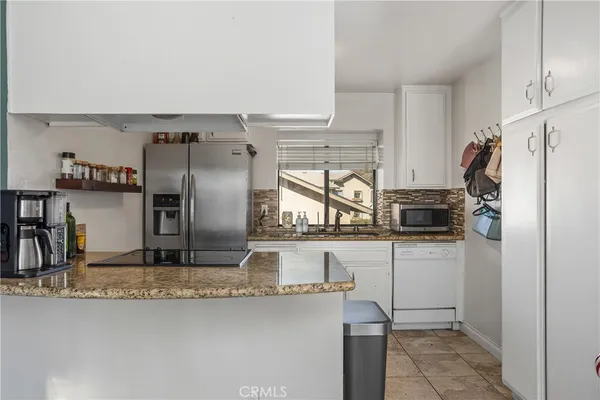 a kitchen with stainless steel appliances granite countertop a refrigerator a stove and a sink