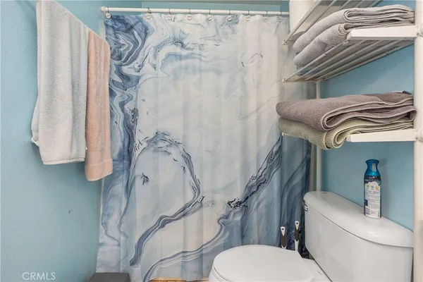 a bathroom with a toilet and a shower curtain