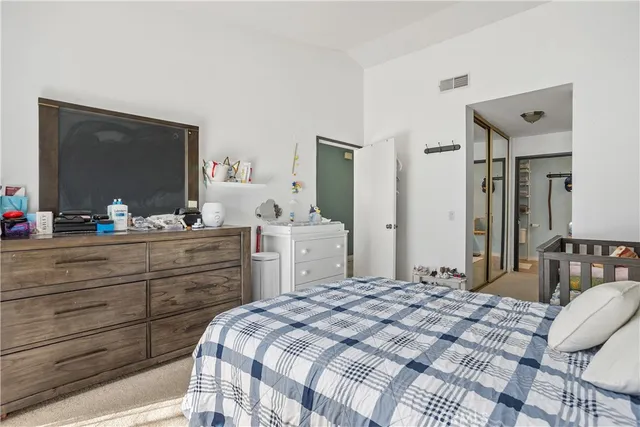 a bedroom with a bed and a large mirror