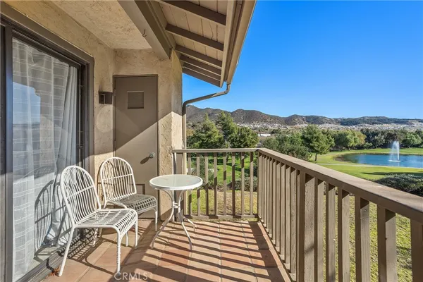 a balcony with wooden floor and outdoor seating