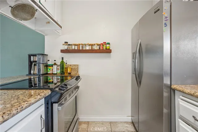 a kitchen with stainless steel appliances granite countertop a refrigerator and a stove