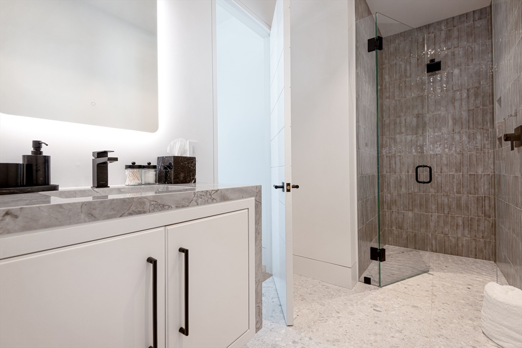 30 Devon Street, Unit THE DIPS Nantucket, MA 02554 - Photo 13 of 42 a bathroom with a granite countertop sink a mirror and shower