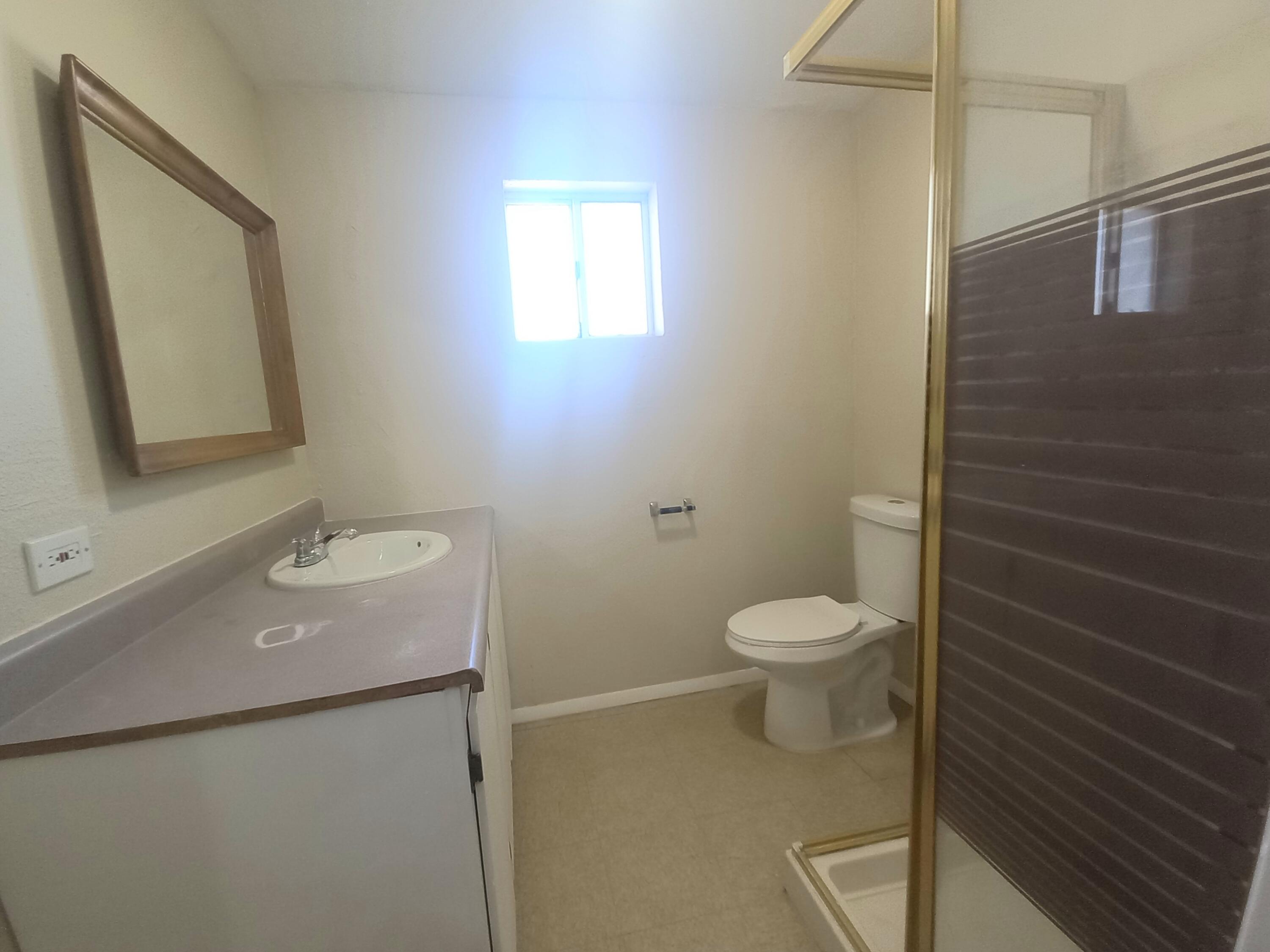 9073 Hull Street Mojave, CA 93501 - Photo 13 of 16 a bathroom with a toilet a sink and mirror