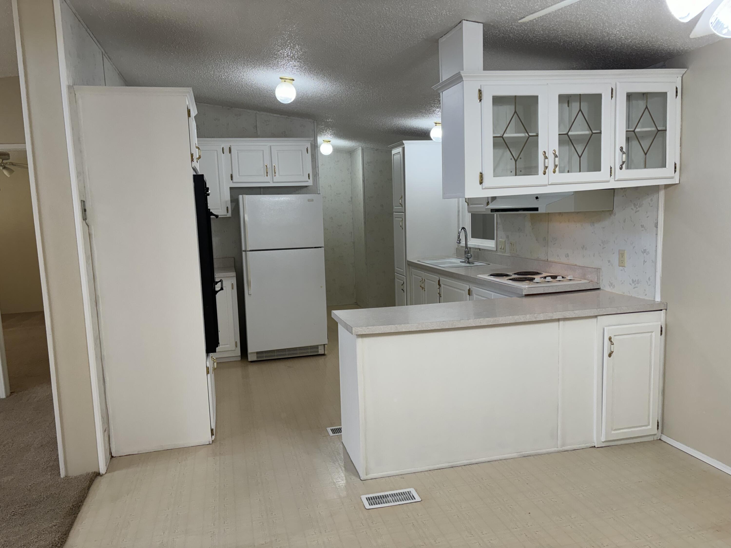 9073 Hull Street Mojave, CA 93501 - Photo 8 of 16 a kitchen with a refrigerator sink and cabinets