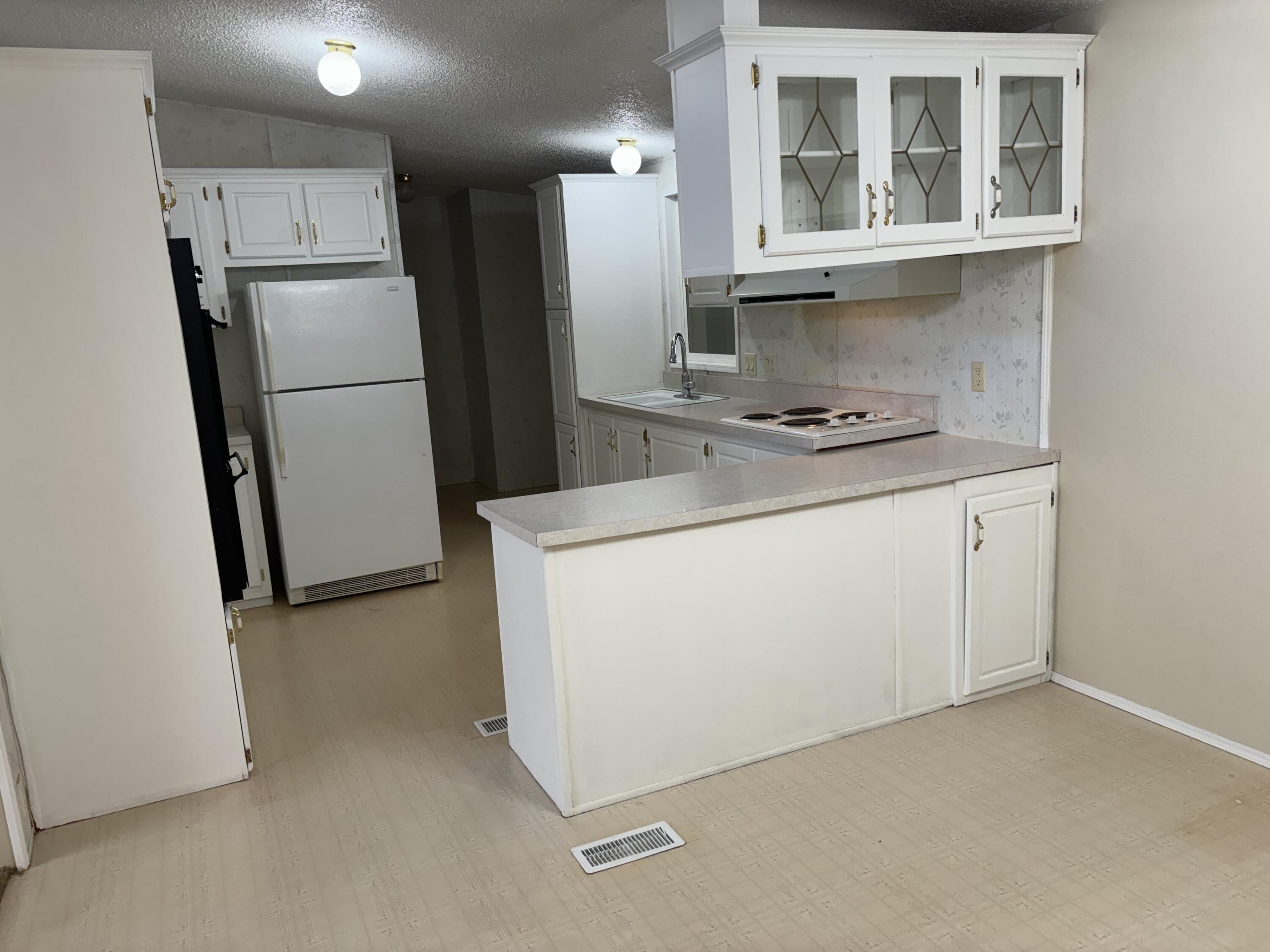 9073 Hull Street Mojave, CA 93501 - Photo 10 of 16 a kitchen with a refrigerator sink stove and cabinets