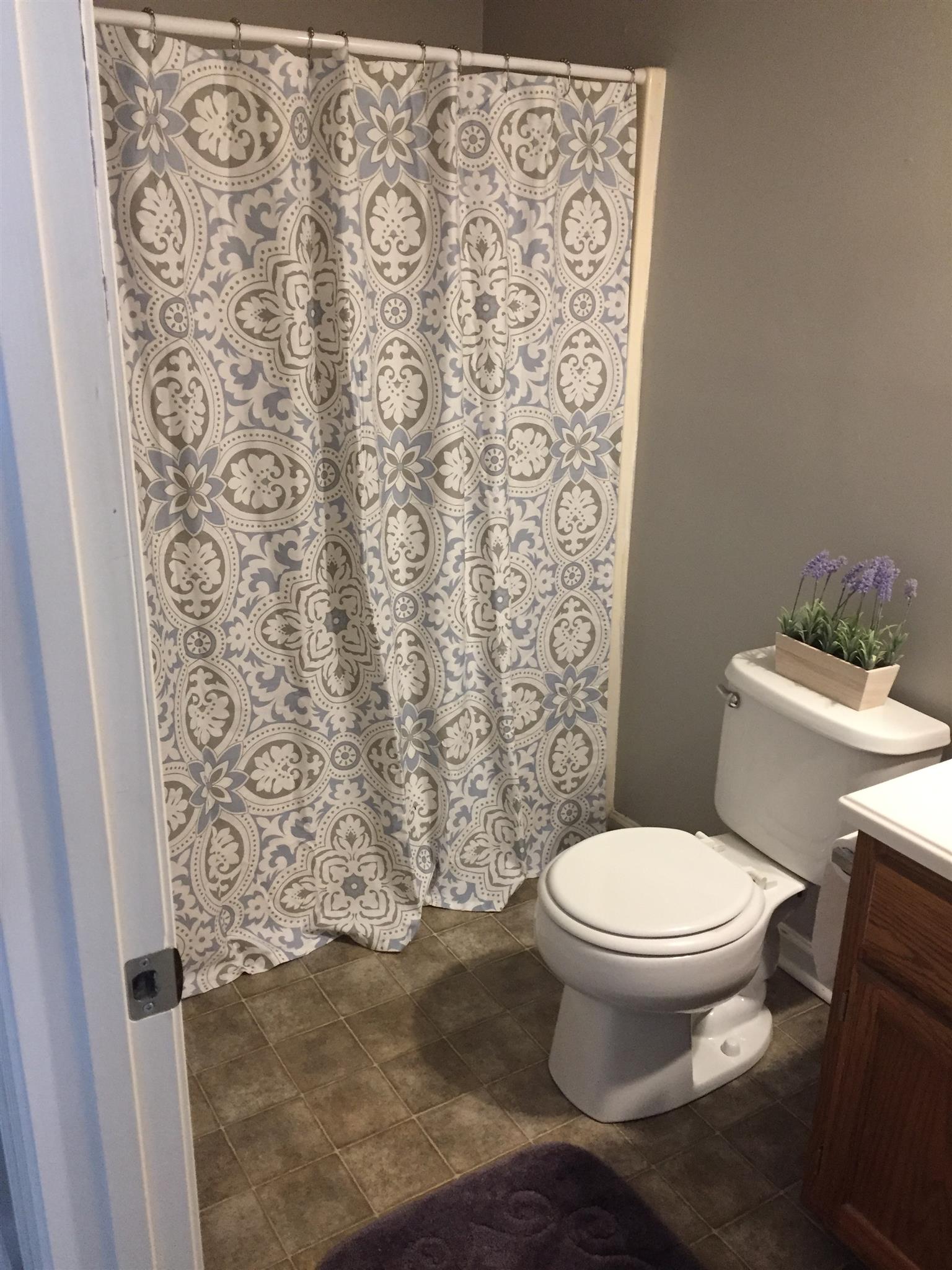 2308 Benay Road Nashville, TN 37214 - Photo 7 of 18 a white toilet sitting next to a shower curtain