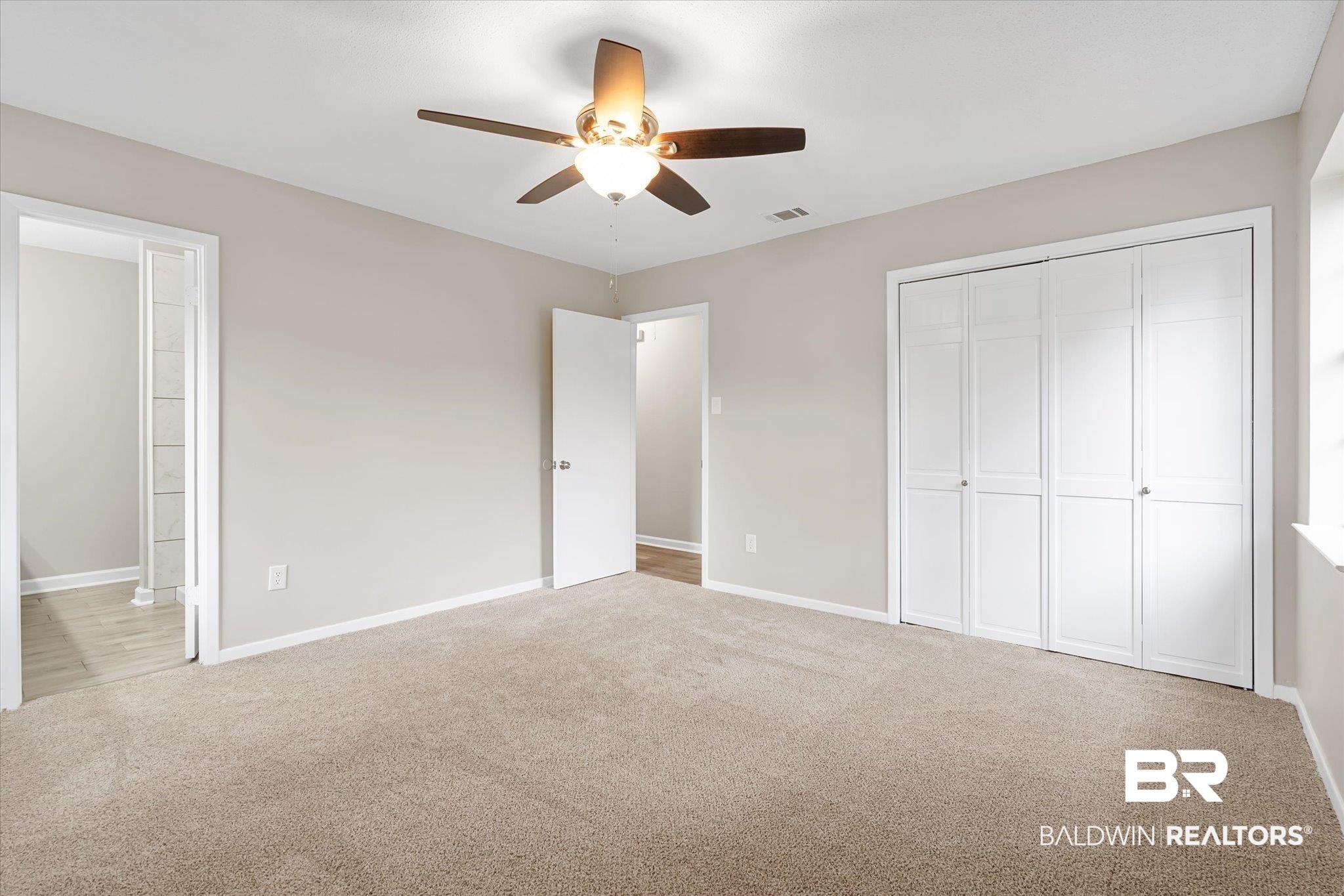 5015 Golfway Drive Eight Mile, AL 36613 - Photo 15 of 31 Unfurnished bedroom with connected bathroom, ceiling fan, a closet, and light carpet