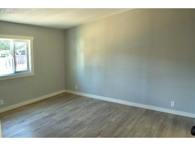 700 Northeast 183rd Avenue, Unit 7 Portland, OR 97230 - Photo 19 of 27 a view of an empty room with wooden floor and a window
