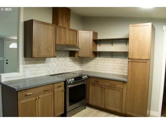 a kitchen with stainless steel appliances granite countertop a refrigerator a sink and white cabinets