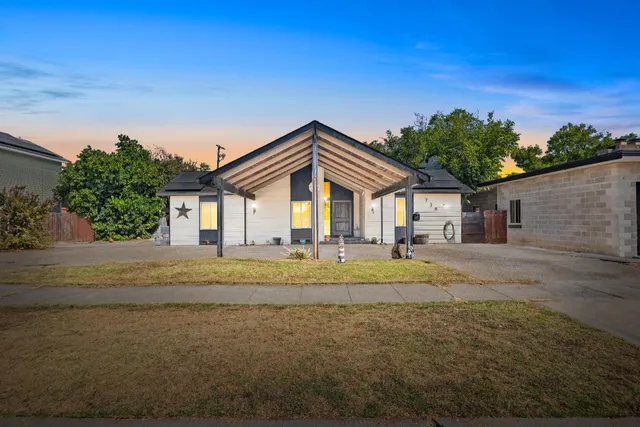 a view of house with outdoor space and trees in the background