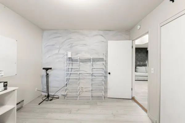 a view of a multi story residential apartment building with yard and parking space