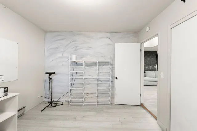 a view of a multi story residential apartment building with yard and parking space