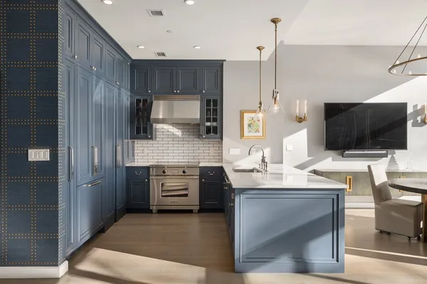 a kitchen with stainless steel appliances kitchen island granite countertop a sink stove and microwave