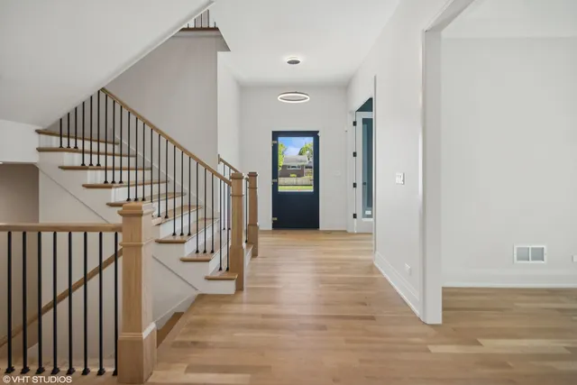 a view of a hallway with wooden floor and entryway