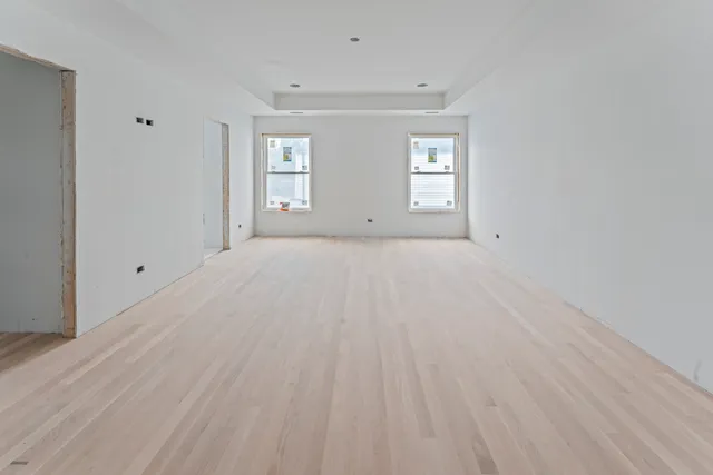 a view of a hallway with wooden floor and entryway