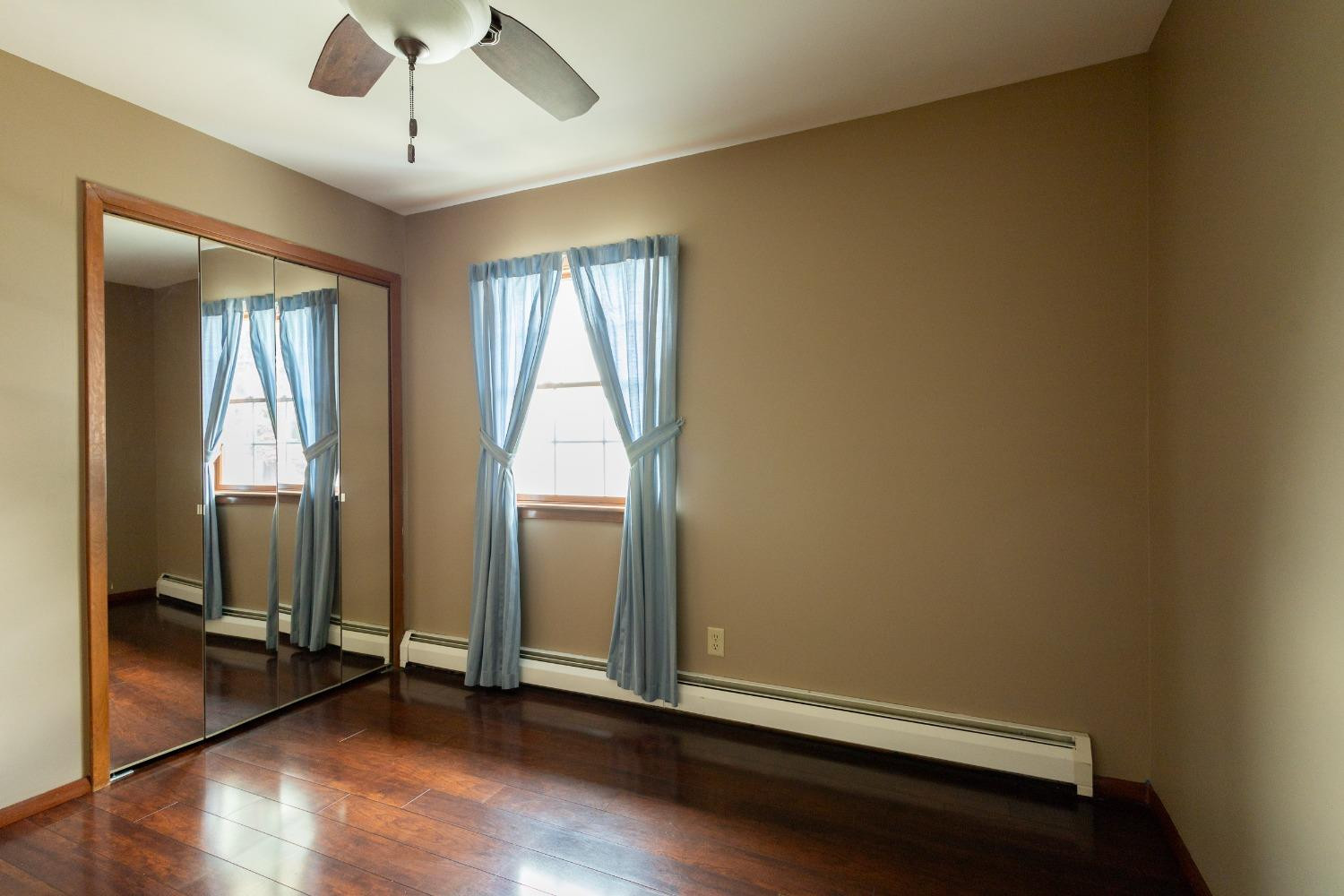 934 West Pine Street Griffith, IN 46319 - Photo 7 of 12 an empty room with wooden floor and windows
