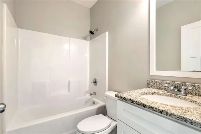 a bathroom with a granite countertop sink toilet bathtub and shower