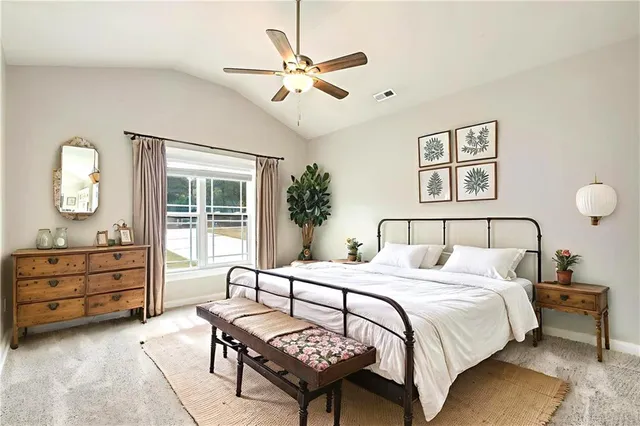 a bedroom with a large bed and a chandelier