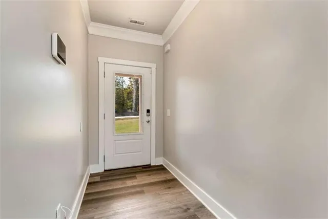 a view of an empty room with closet and a window