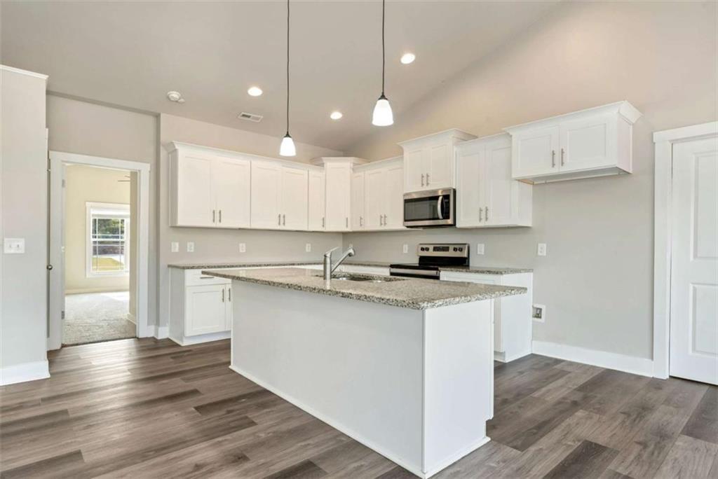 482 North Point Circle Hartwell, GA 30643 - Photo 6 of 32 a kitchen with stainless steel appliances granite countertop a stove top oven a refrigerator a sink and dishwasher with wooden floor