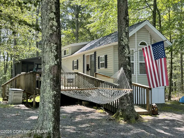 a view of a house with a wooden deck back yard