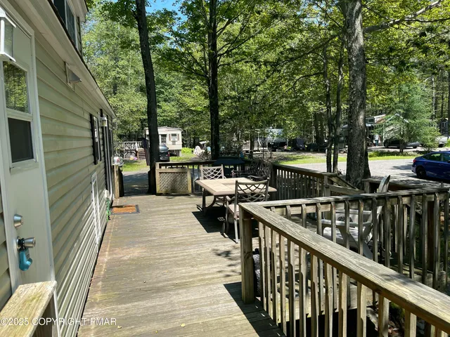 a balcony with wooden floor and outdoor seating