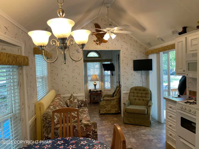 a living room with furniture a chandelier and a flat screen tv