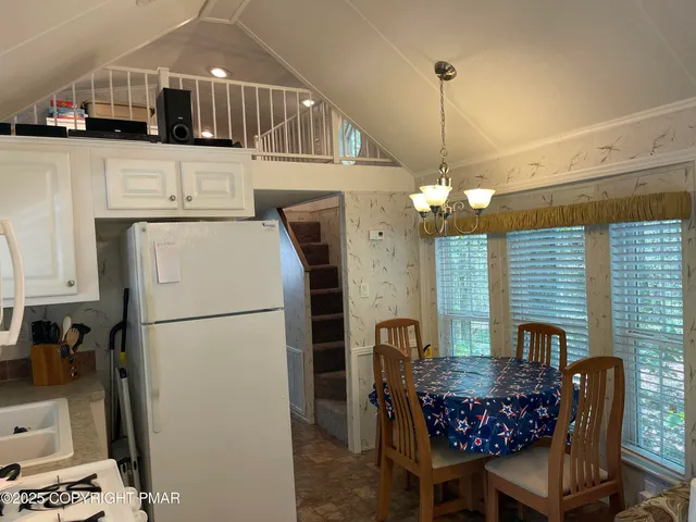a kitchen with stainless steel appliances kitchen island granite countertop a refrigerator a stove a sink dishwasher with a dining table and chairs