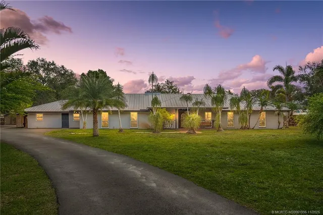 a front view of a house with a yard and lake view