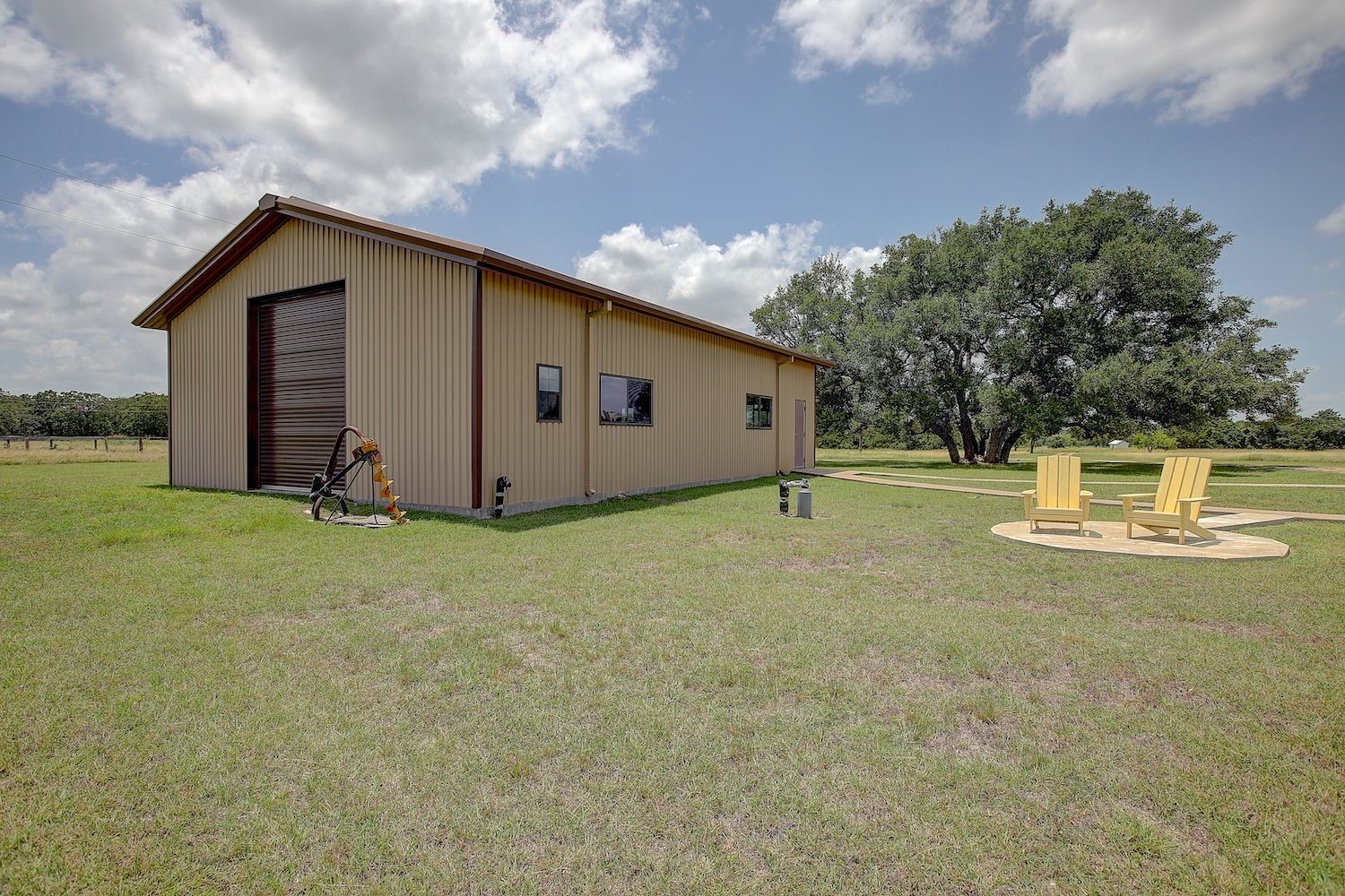 9414 Laird Road Round Top, TX 78954 - Photo 6 of 50 Another view of the metal building garage showing the door height and outdoor seating area dedicated to the views