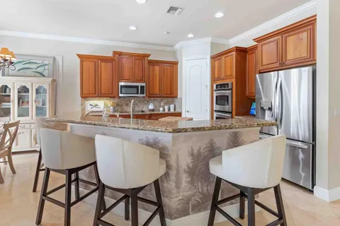 a view of a dining room with furniture a chandelier and a window