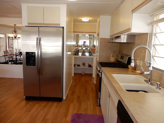 a kitchen with kitchen island a counter top space wooden floor and stainless steel appliances