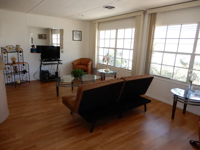 a living room with furniture flat screen tv and wooden floor