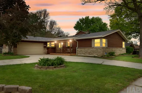 a front view of a house with a garden and yard