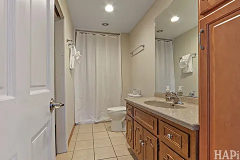a bathroom with a double vanity sink toilet and shower