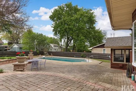 a front view of a house with swimming pool having outdoor seating