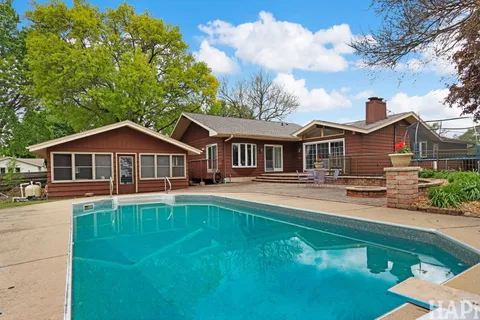 a view of swimming pool with outdoor seating and plants