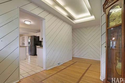 a view of a hallway with wooden floor and a bathroom