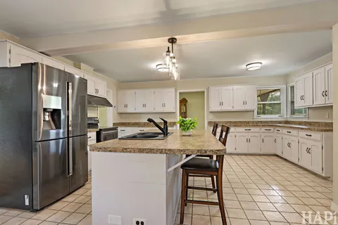 a kitchen with granite countertop a sink appliances a counter space and cabinets