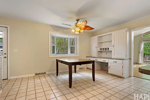 a view of a workspace with furniture and a window