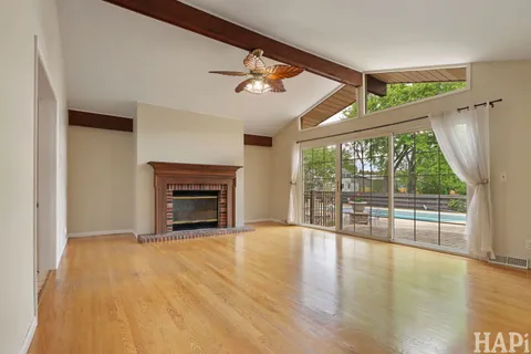 wooden floor fireplace and windows in an empty room