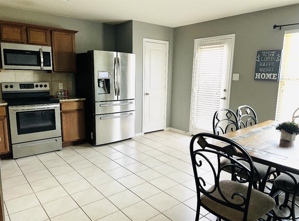 2302 San Marcos Drive Forney, TX 75126 - Photo 8 of 27 a kitchen with stainless steel appliances a stove a refrigerator and a microwave