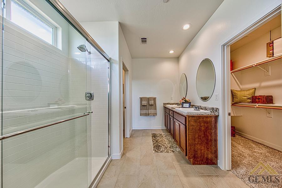 Undisclosed Address Bakersfield, CA 93311 - Photo 6 of 12 a spacious bathroom with a granite countertop sink mirror and shower