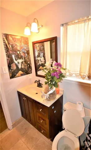 a bathroom with a granite countertop sink toilet and mirror