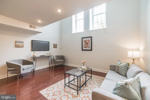 a living room with furniture and wooden floor