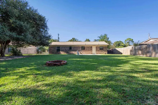 a view of house with garden and tall trees