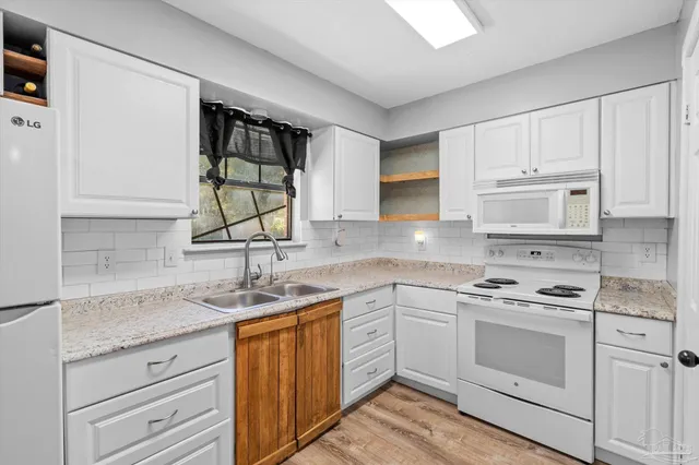 a kitchen with a refrigerator sink and cabinets