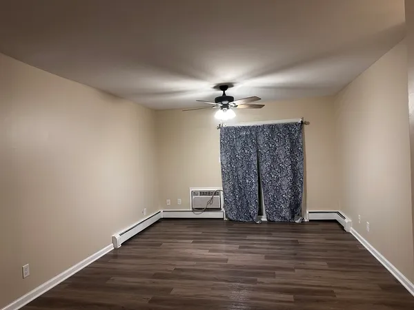 a view of wooden floor in an empty room with a chandelier